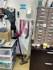 Section containing rulers, iron hanger, quarter size dress form, and vacuum.